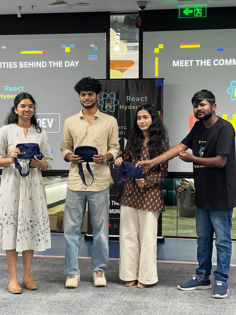 Gitora team recognized as winners at MLH Hacktoberfest 2026, React Hyderabad, holding event pouches in front of the React Hyderabad banner